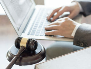 Hands typing on lapel next to gavel